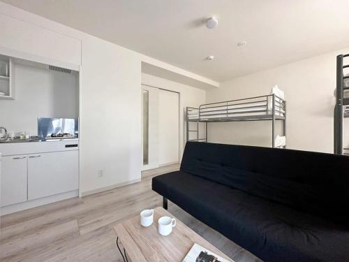 尾道市bHOTEL Yutori - 1Br Apt with Balcony for 4 Ppl in Onomichi的带沙发和双层床的客厅