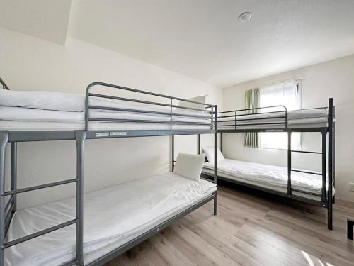 尾道市bHOTEL Yutori - 1Br Apt with Balcony for 4 Ppl in Onomichi的一间房间,设有三张双层床