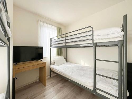 a bedroom with two bunk beds and a flat screen tv at bHOTEL Yutori - Attractive 1Br Apt for 4 people in Onomichi in Onomichi