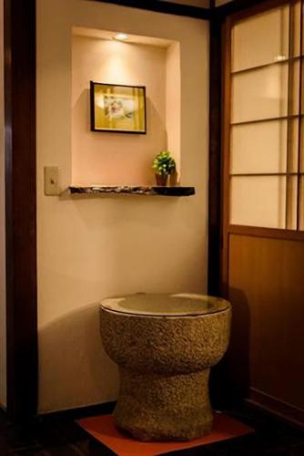 a bathroom with a stone bowl on the wall at bLOCAL Bingo Yamamo - Experience at Traditional Japanese House in Onomichi