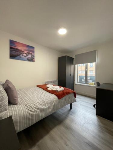 een slaapkamer met een bed met een rode deken erop bij Downtown Sheffield Retreat in Sheffield