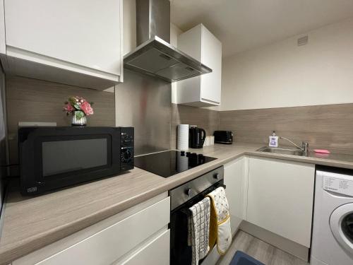 a kitchen with a microwave and a sink at Downtown Sheffield Retreat in Sheffield