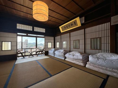 a room with a row of pillows on the floor at bLOCAL Bingo Yamamo - Experience at Traditional Japanese House in Onomichi