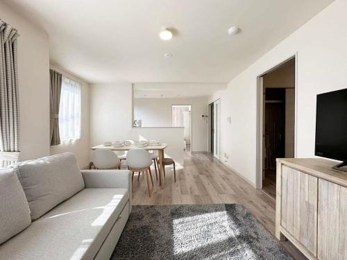 a living room with a couch and a table at Yutori by b hotel - Spacious 2BR Apartment very near the Station in Onomichi