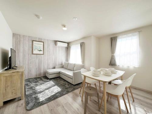 a living room with a table and a couch at Yutori by b hotel - Spacious 2BR Apartment very near the Station in Onomichi