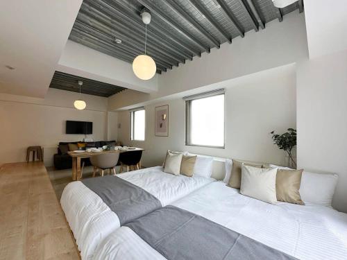 広島市にあるbHOTEL Arts Dobashi - Studio Apt for 6 Ppl Near Peace Parkのテーブル付きの客室で、白い大型ベッド1台が備わります。