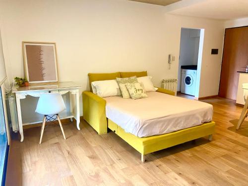 sypialnia z żółtym łóżkiem i biurkiem w obiekcie Depto Genova, Zona Norte, Cochera disponible w mieście Rosario