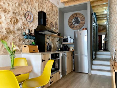 cocina con nevera, mesa y sillas amarillas en AltHouse Canet lo Roig, en Canet lo Roig