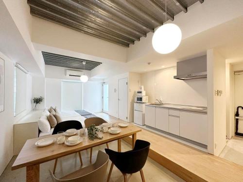 廣島的住宿－bHOTEL Arts Dobashi - Studio Apt for 6 Ppl Near Peace Park，厨房以及带桌椅的起居室。