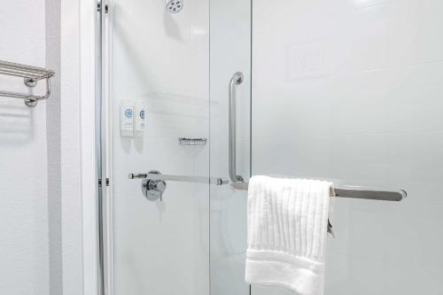 ducha con puerta de cristal y toalla blanca en Comfort Inn near Great Smoky Mountain National Park, en Maggie Valley
