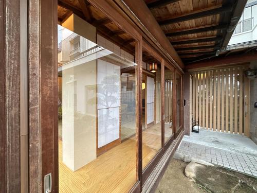 bLOCAL Itsuki - Charming Private House in Miyajimaguchi Near Itsukushima Shrine Upto 18 ppl في هاتسوكايتشي: إطلالة خارجية على منزل به نافذة زجاجية