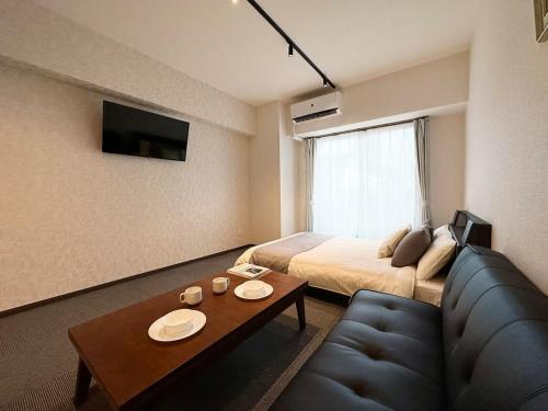 a hotel room with a bed and a couch at bHOTEL Nagomi - Cozy 1BR Apartment with Balcony for 3Ppl in Hiroshima