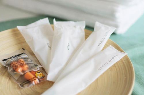 a wooden plate with two white napkins and towels at bLOCAL Itsuki - Charming Private House in Miyajimaguchi Near Itsukushima Shrine Upto 18 ppl in Hatsukaichi