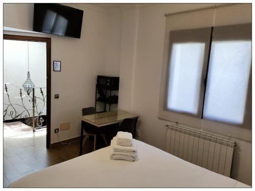 バルデペニャスにあるMagnífico Alojamiento en el centroのベッド、デスク、窓が備わる客室です。