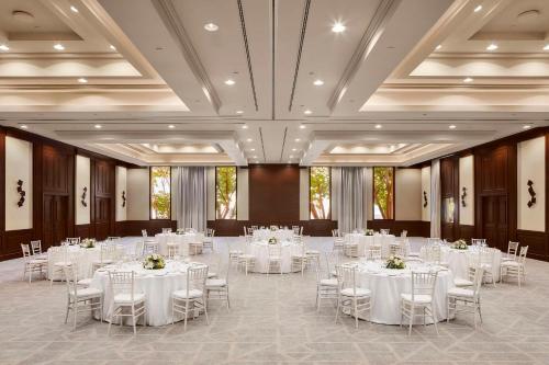 un salón de banquetes con mesas y sillas blancas en Tivoli La Caleta Resort en Adeje