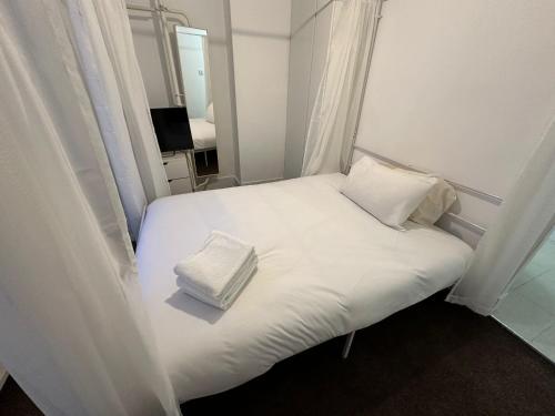 a bed with two pillows on it in a room at 2 bedroom flat Wembley in London