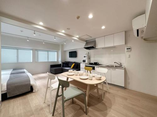 a kitchen and a living room with a table and a bed at bHOTEL F-style - 1BR Apt Great Location for 6Ppl in Hiroshima