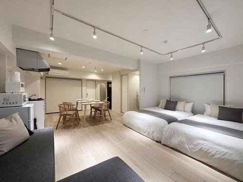 a large bedroom with a large bed and a kitchen at bHOTEL F-style - Cozy New Apt in the Heart of the City in Hiroshima