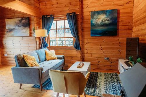 a living room with a couch and a table at Finlodge- Pet-Friendly Scandinavian Cabin in Callington