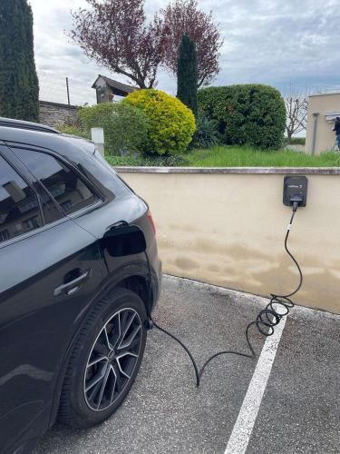 a car is plugged into a electric car charger at La Bonbonniere - Sure Hotel Collection by Best Western in Talant