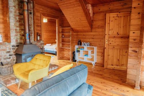 a living room with a blue couch and a fireplace at Finlodge- Pet-Friendly Scandinavian Cabin in Callington