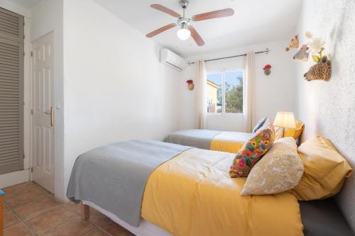 a bedroom with two beds and a ceiling fan at Casa Rosa in Torrent