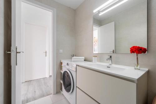 a bathroom with a washing machine and a sink at Apartamento moderno y soleado in Torredembarra