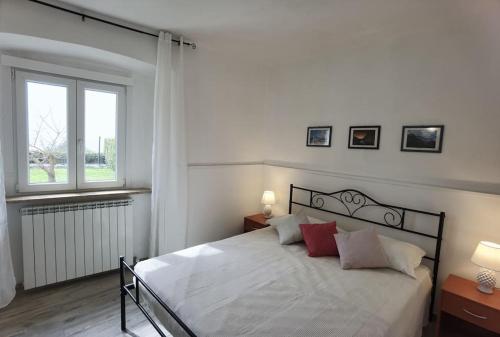 1 dormitorio con 1 cama blanca grande con almohadas rojas en Il covo degli Amanti, en Fara in Sabina