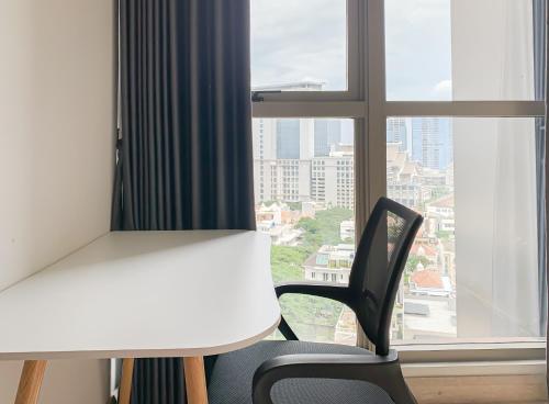 a desk and a chair in front of a window at Comfort One Bed Room Apartment Gold Coast PIK in Jakarta