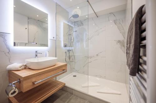 ein Bad mit einem Waschbecken und einer Dusche in der Unterkunft Hotel Royal in Timmendorfer Strand
