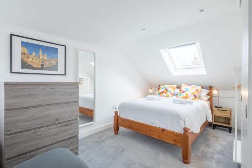 a white bedroom with a bed and a mirror at Refurbished High Spec CENTRAL Family Home in Cambridge