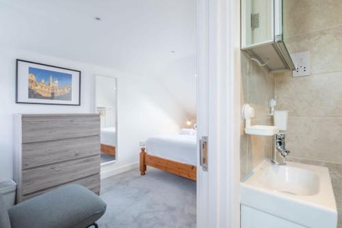 een badkamer met een wastafel en een bed in een kamer bij Refurbished High Spec CENTRAL Family Home in Cambridge