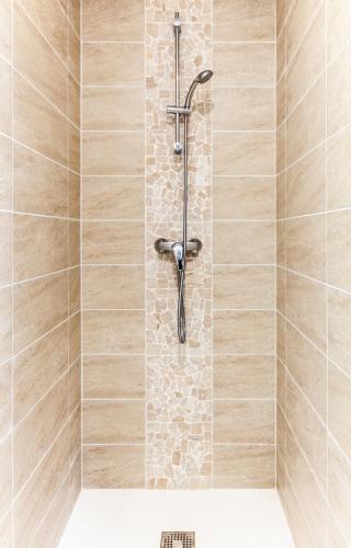 a shower with a shower head in a bathroom at Espaces Gîtes in Sainte-Escobille