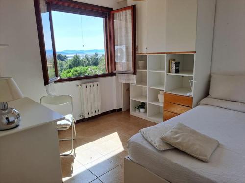 Schlafzimmer mit einem Bett, einem Schreibtisch und einem Fenster in der Unterkunft Nice Apartment in Margine Rosso in Quartu SantʼElena