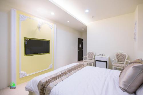 馬公市的住宿－澎湖森源民宿 SunYoung，一间卧室配有一张床、一台电视和椅子
