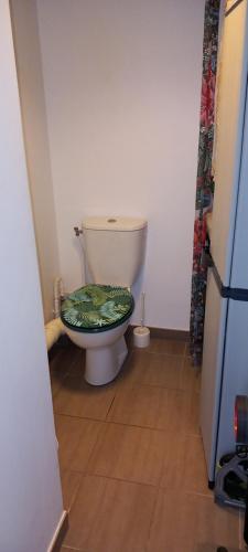 La salle de bains est pourvue de toilettes avec un siège vert. dans l'établissement Bezons La Defense, à Bezons