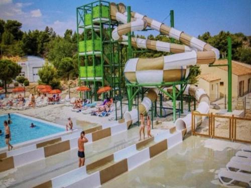 un parc aquatique avec un toboggan et une piscine dans l'établissement Mobil home Clim, Tv - Camping Falaise Narbonne Plage 4 étoiles - 004, à Narbonne-Plage