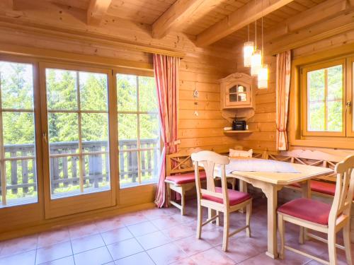 a dining room with a table and chairs and windows at 1A Chalet Enzianhuette - im Wander und Skigebiet in Elsenbrunn