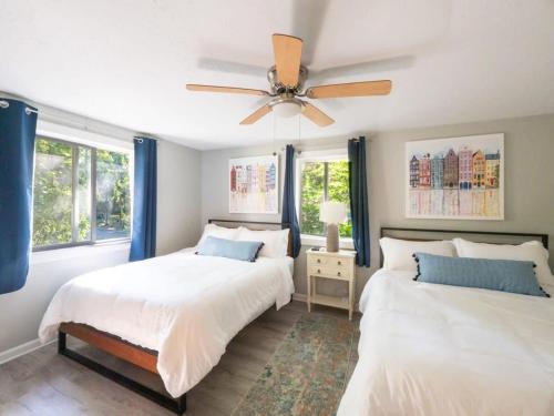 a bedroom with two beds and a ceiling fan at Berkshire Vacation Rentals: Leicester Lake Front Home Come Relax in Leicester