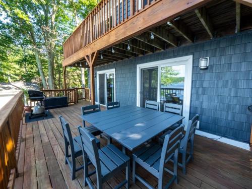 una terraza de madera con mesa y sillas azules en Berkshire Vacation Rentals: Leicester Lake Front Home Come Relax, en Leicester