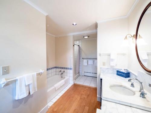 uma casa de banho branca com uma banheira e um lavatório em Berkshire Vacation Rentals: Renovated Five Bedrooms In Historic Williamstown em Williamstown