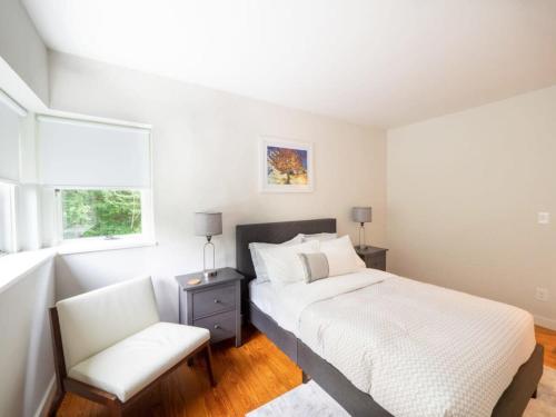 a bedroom with a bed and a chair and a window at Berkshire Vacation Rentals: High End Berkshires Getaway in East Hillsdale
