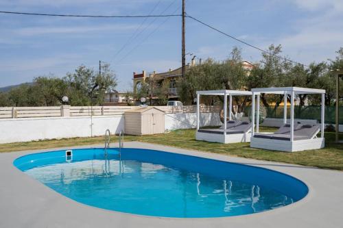 a swimming pool with a gazebo and a blue pool at Hidden Heaven Luxury Villa in Ambelókipoi