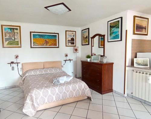 a bedroom with a bed and a dresser and pictures on the wall at A casa dell' Artista in Fiumicino