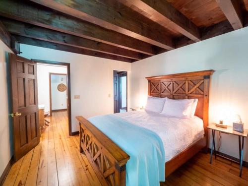 een slaapkamer met een groot bed met een houten hoofdeinde bij Berkshire Vacation Rentals: Pristine Home In Becket Woods in Becket