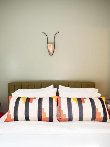 a bed with black and white pillows and a light on the wall at Private Berkshires Home On 5+ Acres Rustic & Chic in Otis