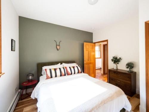 a bedroom with a white bed and a gray wall at Private Berkshires Home On 5+ Acres Rustic & Chic in Otis