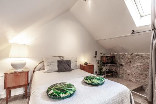 ein Schlafzimmer mit einem Bett mit zwei Kissen darauf in der Unterkunft Espaces Gîtes in Sainte-Escobille