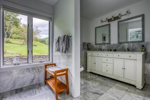 a bathroom with a shower and a sink and a window at Berkshire Vacation Rentals: The Brookman: Renovated 6000 SF Estate On 40 Acres in Williamstown