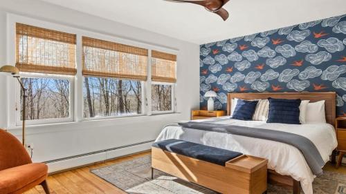 - une chambre avec un lit et un mur de fenêtres dans l'établissement Hupi House - A Peaceful Wooded Lakeside Retreat, à Monterey